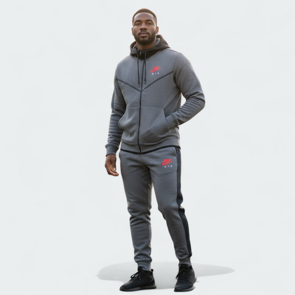 Nike Air NSW Fleece Men's Tracksuit in heather grey, front view worn by a model showing the full-zip hoodie and matching tapered joggers, with Nike Air logos visible.