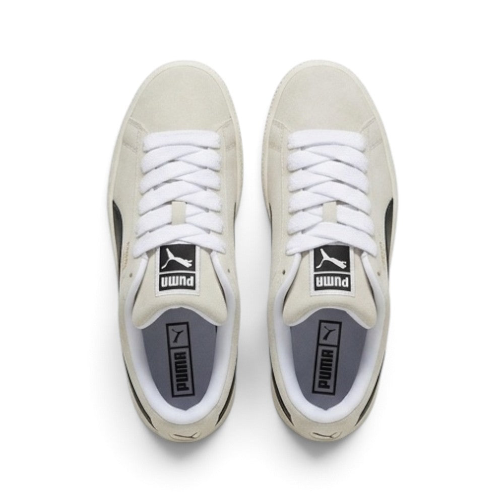 Direct overhead look at both shoes, displaying the rounded Sand suede toe boxes, oversized white fat laces across heavily padded foam tongues with black-and-white woven PUMA tags, and dark footbeds.
