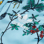 Close-up of Adidas logo on fabric with floral and nature-themed design
