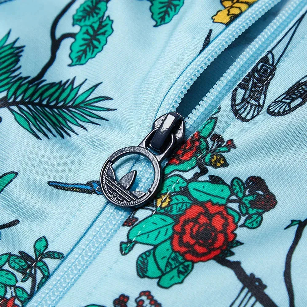 Close-up of a floral-patterned fabric with a zipper and a decorative button.