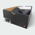 A pair of black Jordan sneakers inside an open black Air Jordan shoebox, photographed on a light gray background.