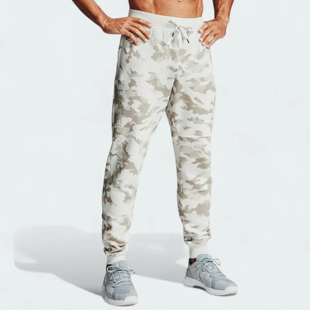 Under Armour Rival Fleece Camo Track Pants Men's in onyx white camouflage print, front view showing the tapered leg, elastic drawcord waist, and front pockets. Main image