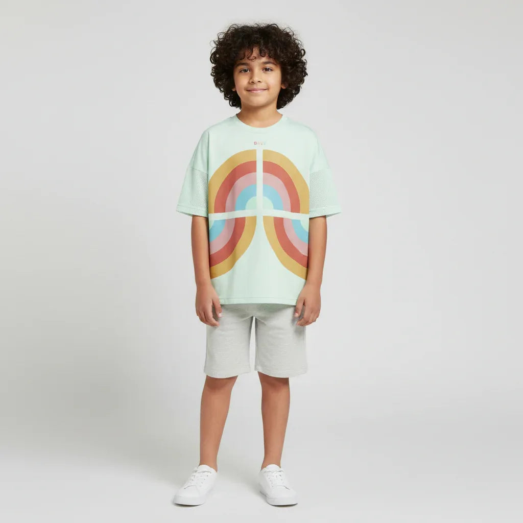 Child wearing a light green t-shirt with a rainbow design on a white background Main image