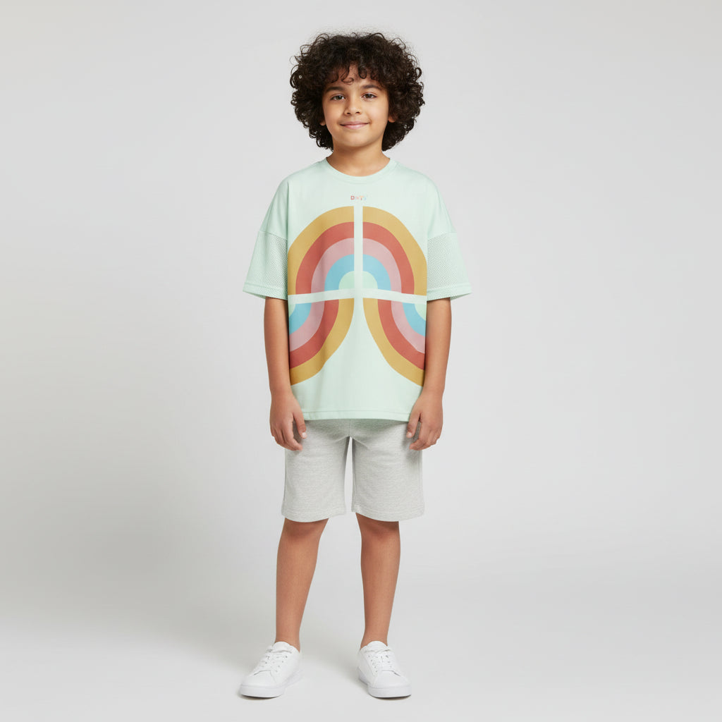 Child wearing a light green t-shirt with a rainbow design on a white background