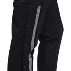 Close-up zoom on the Adidas 7/8 Cropped Snap Pants Women's in black, showing the individual snap buttons along the side and the texture of the knit fabric.