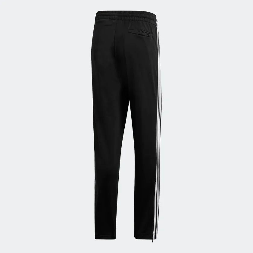 Adidas Firebird Track Pants Men's in black, back view showcasing the tapered leg fit and ribbed cuffs.