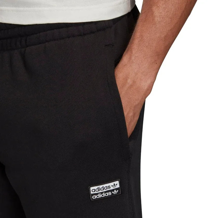 Close-up zoom on the Adidas R.Y.V. Sweat Pants Men's in black, showing the soft fleece fabric texture and any subtle R.Y.V. or Trefoil logo detail.