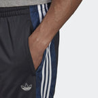 Adidas Men's BX-20 Graphic Sweat Pants shows the zipped pocket in use with the patterns in the material . 
