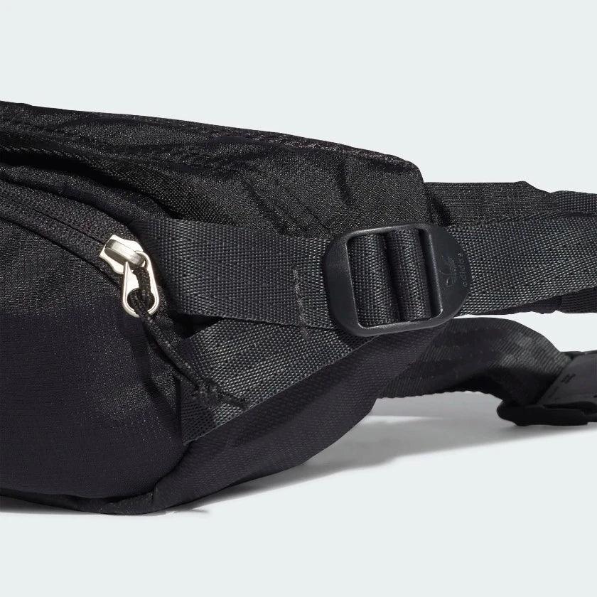 Close-up zoom on the Adidas Adventure Waist Bag in black, showing the ripstop fabric texture and the woven Adidas patch on the front.