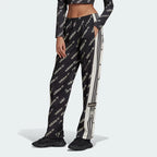 A pair of black Adidas Adibreak track pants with white stripes and monogrammed Adidas logos, featuring a drawcord on elastic waist.